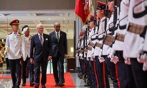 Sweden's King Carl XVI Gustaf inspects an honour guard with Singapore’s President Tharman Shanmugaratnam at the Parliament House in Singapore