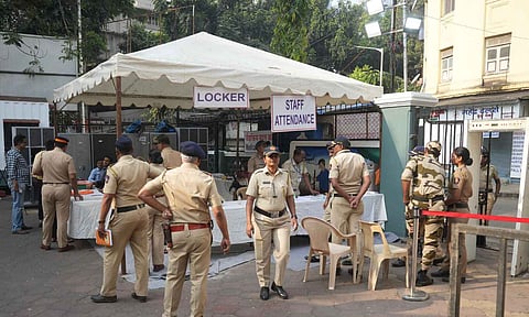 Police and security personnel stand guard a barricaded road near a counting center amid the counting of votes for the Maharashtra Assembly elections (PTI)
