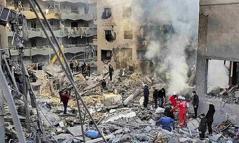 Rescue workers and people search for victims at the site of an Israeli airstrike in Beirut, Lebanon (AP)