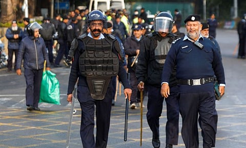 Police officers walk to guard a road to prevent an anti-government rally (Reuters)