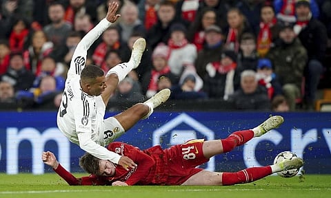 Liverpool’s Conor Bradley tackles Real Madrid’s Kylian Mbappe during the Champions League opening phase soccer match between Liverpool and Real Madrid at Anfield Stadium (AP)
