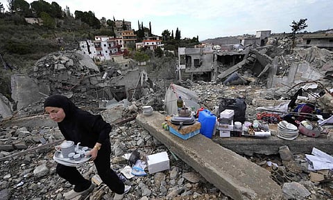 A woman collects the remains of her destroyed house after she returned to Chehabiyeh village, southern Lebanon