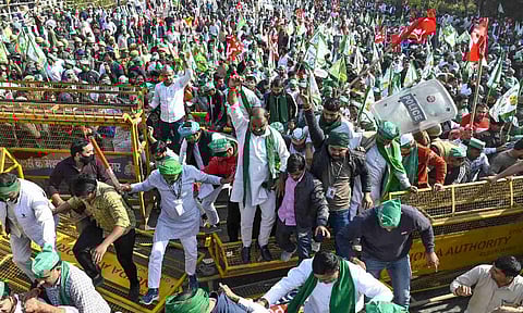 Farmers sit on a road after they were stopped by police during their protest march towards the national capital, near Dalit Prerna Sthal, in Noida (PTI)&nbsp;