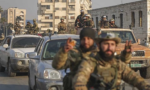 Syrian opposition fighters ride along the streets aftermath of the opposition's takeover of Hamas (AP)