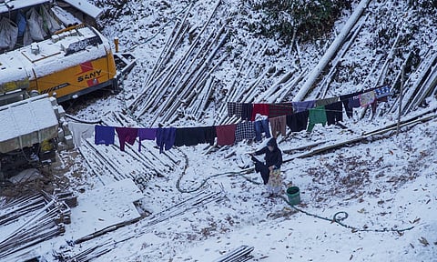 A woman dries clothes in sun after fresh snowfall in Shimla, Himachal Pradesh, Monday, Dec. 9, 2024 (PTI)&nbsp;