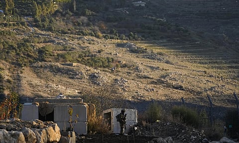An Israeli soldier stands guard at a security fence near the so-called Alpha Line (AP)