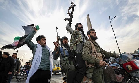 Syrian opposition fighters celebrate after the Syrian government collapsed in Damascus, Syria (AP)