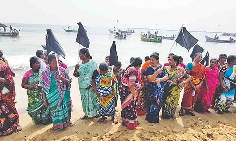 Fisherwomen with black flags at Amalinagar beach near Tiruchendur on Tuesday