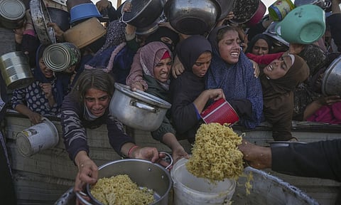 Palestinian girls struggle as they get donated food (AP)