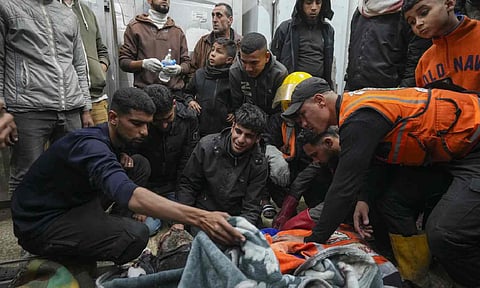 Palestinians mourn over the bodies of civil defense workers victims of an Israeli army strike (AP)