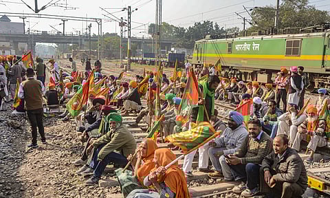 Farmers block railway tracks as part of their state-wide 'Rail Roko' protest to press the Centre into accepting their various demands, including a legally binding minimum support price for crops, in Patiala (PTI)