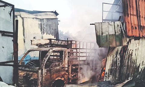 The mini van and a car (not in photo) parked inside the premises were destroyed in fire on Friday