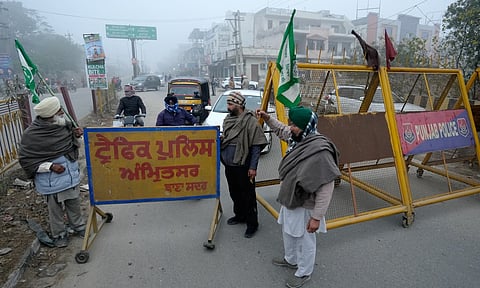Farmers block a road during the statewide 'bandh' called as part their ongoing protest, in Amritsar