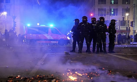 Police officers stand guard in the streets after fireworks for the New Year's celebrations in Berlin (AP)