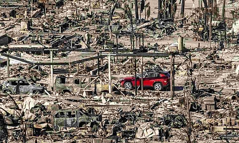 A car drives past homes and vehicles destroyed by the Palisades Fire at the Pacific Palisades Bowl Mobile Estates (AP)&nbsp;