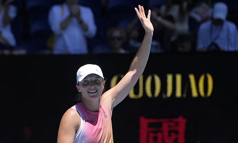 Iga Swiatek of Poland waves after defeating Emma Raducanu of Britain in their third round match at the Australian Open tennis championship in Melbourne (AP)