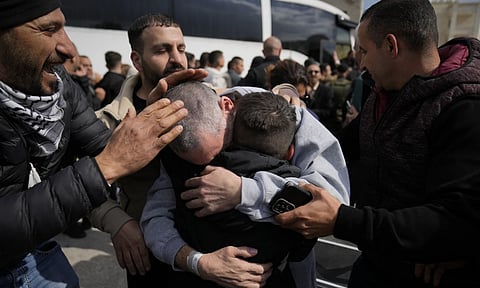 Palestinian prisoners are greeted as they exit a Red Cross bus after being released from Israeli prison following a ceasefire agreement between Israel and Hamas (AP)