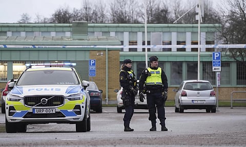 Police officers stand guard near the scene of a shooting at an adult education center on the outskirts of Orebro