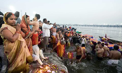 Devotees pray after taking holy dip at the Sangam on the occasion of 'Maghi Purnima' during the ongoing Maha Kumbh Mela