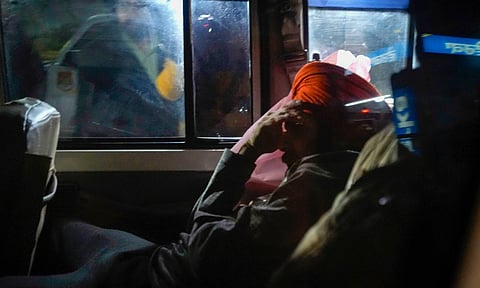 Indians deported from the U.S. being escorted by the police as they leave the airport upon their arrival, in Amritsar, early Sunday (PTI)&nbsp;