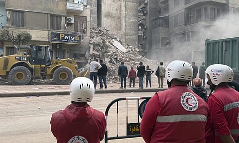 Rescuers search through the rubble of a collapsed six-story apartment building in Cairo (AP)&nbsp;