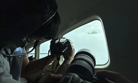 A Chinese military helicopter flies close to a Philippine Bureau of Fisheries and Aquatic (BFAR) aircraft above Scarborough shoal (AP)