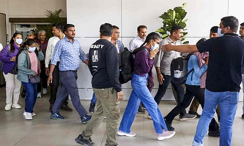 Immigrants deported from USA, being escorted upon their arrival at the airport, in Ahmedabad, Monday (PTI)