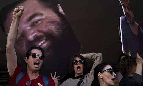Demonstrators hold photos depicting the faces of Israeli hostages who are being held in the Gaza Strip, during a protest demanding their release from Hamas captivity, in Tel Aviv (AP)