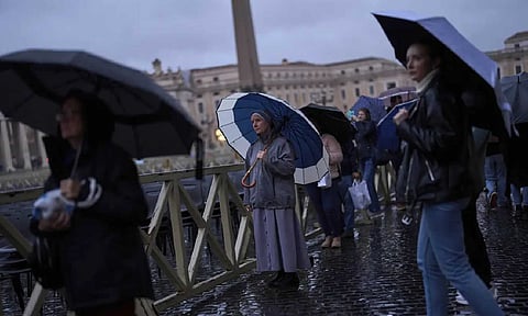 People pray as they follow a live broadcasted Rosary prayer for Pope Francis, in St. Peter's Square at the Vatican (AP)