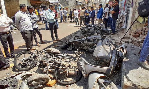 People gather near charred remains of two-wheelers at Hansapuri area amid curfew after violence erupted on Monday night, in Nagpur, Tuesday, March 18, 2025 (PTI)&nbsp;
