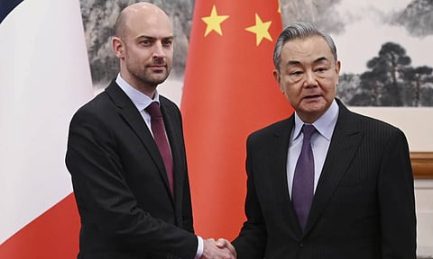French Foreign Minister Jean-Noel Barrot, left, is greeted by China's Foreign Minister Wang Yi at the Diaoyutai State Guesthouse in Beijing (AP)