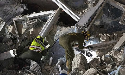 Rescuers search for victims at the site of a high-rise building under construction that collapsed after a strong earthquake(AP)