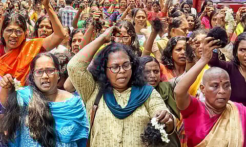 Accredited Social Health Activist (ASHA) workers cut their hair during a protest, demanding an increase in their honorarium, in Thiruvananthapuram (PTI)