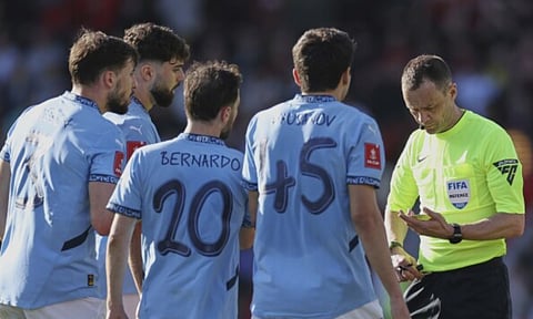 Referee Stuart Attwell, right, discusses with Manchester City players during the English FA Cup quarterfinal soccer match between Bournemouth and Manchester City at the Vitality stadium in Bournemouth (AP)