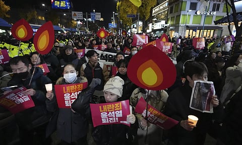 Protesters march to the presidential office after a candlelight vigil against South Korean President Yoon Suk Yeol in Seoul (AP)