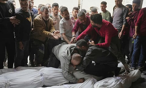 Palestinians mourn over the bodies of their relatives who were killed in an Israeli airstrike in Shijaiyah neighborhood, as they brought to the Baptist Hospital in Gaza (AP)