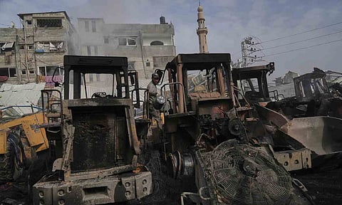 Palestinians examine the remains of bulldozers hit by an Israeli army airstrike in Jabaliya, northern Gaza Strip (AP)