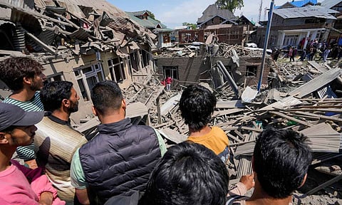 People walk through debris of the house of Ahsan Ul Haq Sheikh, a suspect in the Pahalgam terror attack, which was razed in a blast, in Murran area of Pulwama district (PTI)