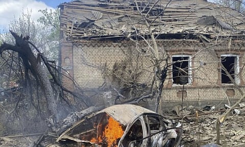 In this photo provided by the Ukrainian Emergency Service, a car burns against the background of a damaged private house following Russia's air raid in the Donetsk region, Ukraine (AP)