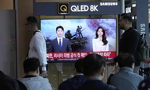 People pass by a TV screen reporting North Korea confirms troops deployment to Russia during a news program at the Seoul Railway Station in Seoul (AP)