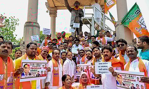 BJP workers stage a protest against installation of a hoarding featuring BR Ambedkar and Samajwadi Party chief Akhilesh Yadav in half faces, at Ambedkar Park