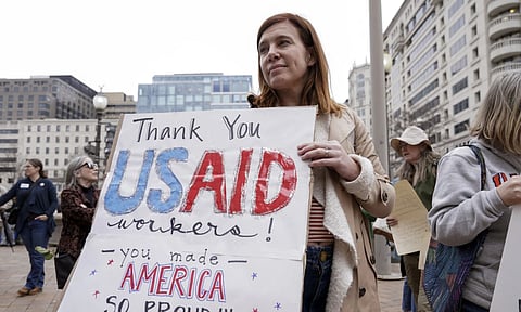 A person carries a sign in supoort of USAID (AP)