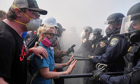 Protesters confront police on the 101 Freeway near the metropolitan detention center of downtown Los Angeles on Sunday (AP)
