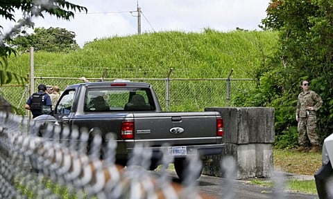U.S. military persons gather near the site of an explosion at a storage site for unexploded ordnances at a U.S. military base in the town of Yomitanson (AP)