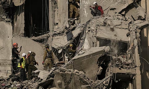 Israeli soldiers and rescue team search for survivors amid the rubble of residential buildings destroyed by an Iranian missile strike (AP)