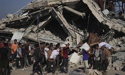 Palestinians carry humanitarian aid packages (AP)