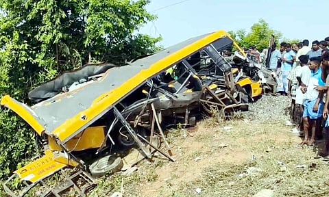 People gather near the wreckage of a vehicle after a school van was allegedly hit by a passing train while attempting to cross a railway track (PTI)