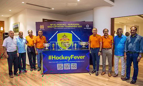 Officials and former Hockey players pose with the trophy during the event