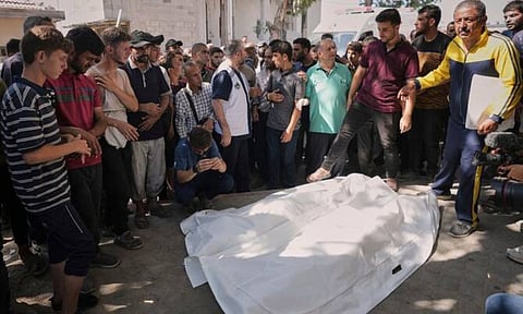 Palestinian mourners gather around the body of the director (AP)