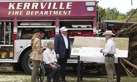 First lady Melania Trump, from left, Texas Gov. Greg Abbott and President Donald Trump are briefed on flood damage in Kerrville, Texas (AP)